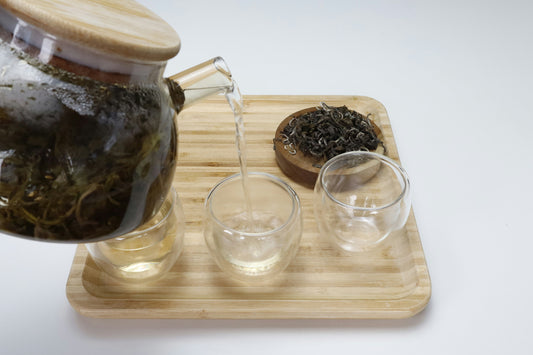 Oolong tea getting poured into transparent cups. 