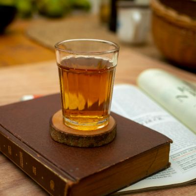 A clear glass vessel filled with oolong tea. 