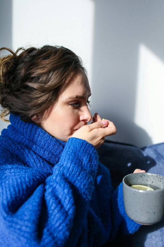 A woman drinking a herbal tea for cough. 